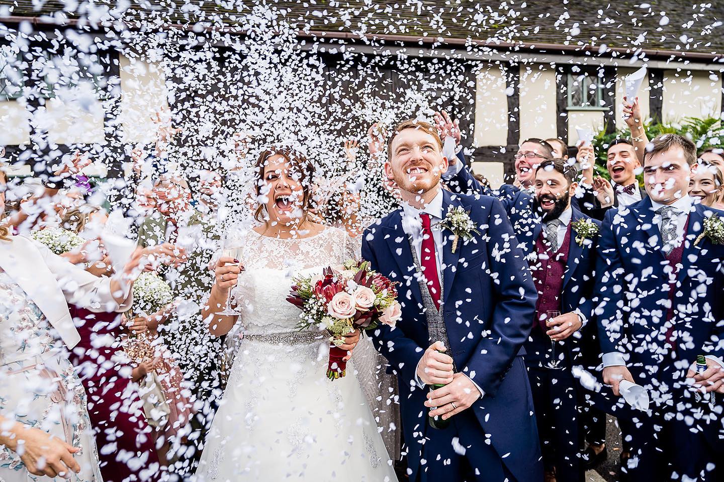 Guests throwing confetti over a bride and groom